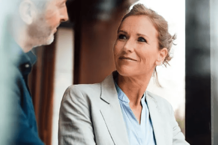 Two people in conversation, woman in light blazer